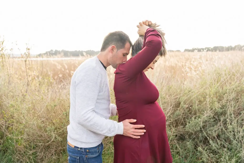 a man kissing a pregnant woman's belly