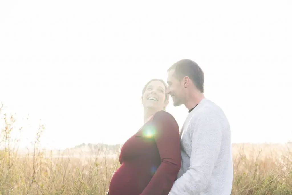 a man and woman standing in a field