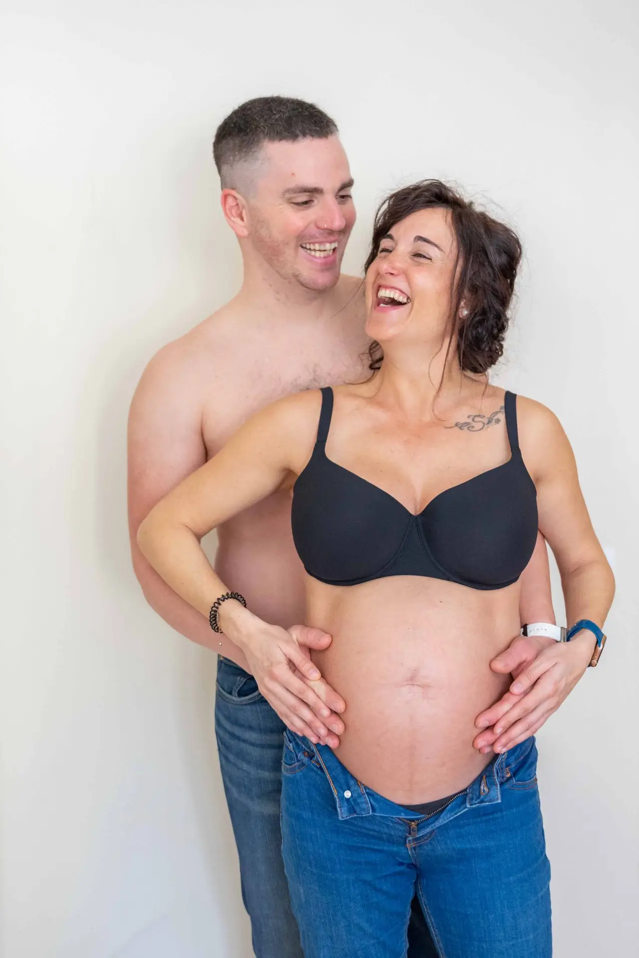 Sara y pareja abrazados en sesión de embarazo en estudio